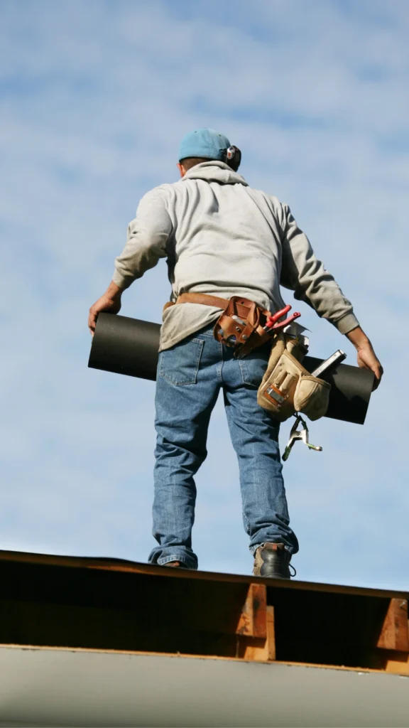 man on a roof with materials and tools